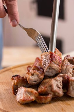 Adam kızarmış et ve yeşil soğan parçaları ile yuvarlak bir ahşap tahta tutar