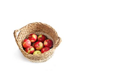 Hasır bir sepette beyaz bir arka planda sulu elmalar. Yukarıdan bak. Metin için boşluk