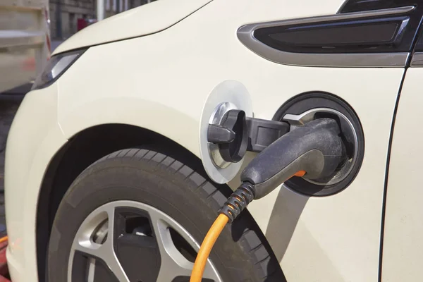 Estación de cargador eléctrico con fuente de alimentación conectada a un coche eléctrico que se está cargando — Foto de Stock