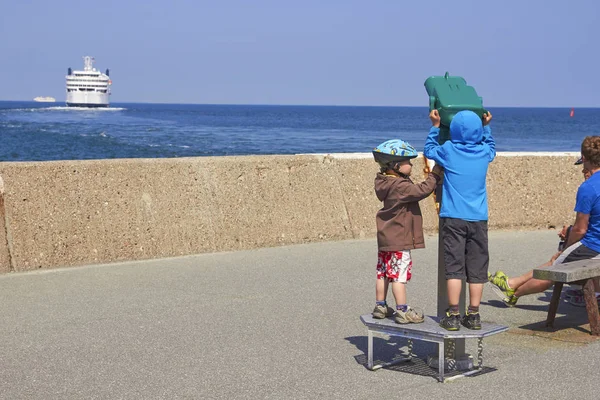 Travemunde, Almanya - 11 Haziran 2013: Çocuk görünüyor üzerine teleskopu gemilerle — Stok fotoğraf