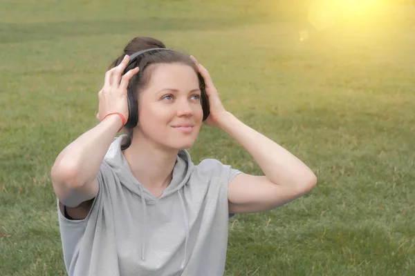 Mulher branca bonita em fones de ouvido ouvindo música — Fotografia de Stock