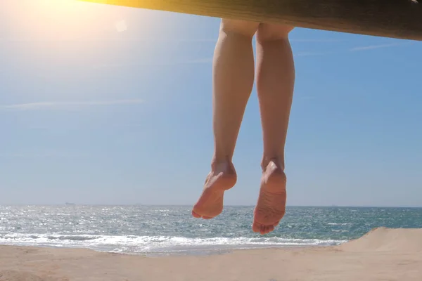 Dangling pieds nus féminins assis sur la plage . — Photo