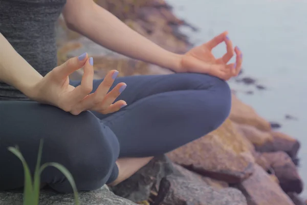 Mujer sentada en la roca y meditando en pose de yoga — Foto de Stock
