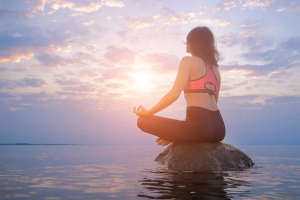 Mujer sentada en la roca en el mar. Concepto de meditación y relajación . — Foto de Stock