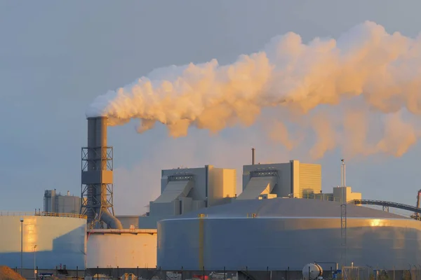 Vervuiling en rook uit de schoorstenen van de plant. Kijk bij zonsondergang — Stockfoto