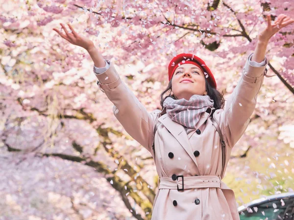 Hermosa mujer feliz disfrutando del olor en un jardín de primavera floreciente — Foto de Stock