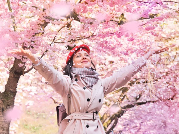 Hermosa mujer disfrutando de un jardín de primavera floreciente — Foto de Stock