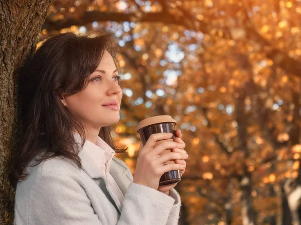 Beautiful woman drinking coffee outdoor enjoying her morning coffee.