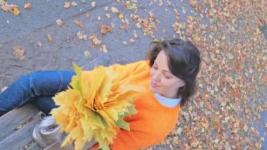 Mutlu bir gülümseme ve sonbahar ile oynamak kadınları bankta bırakır.