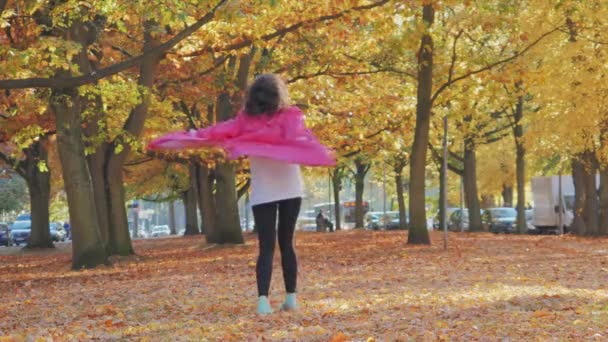 Счастливая женщина, гуляющая в осеннем парке, деревья с осенними листьями — стоковое видео