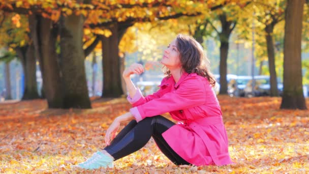 Gelukkige vrouw met herfstblad in park, romantische stemming — Stockvideo