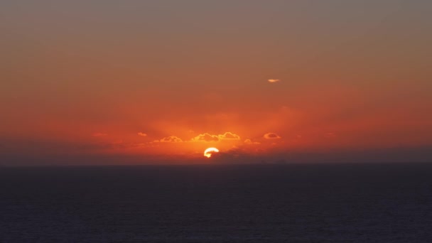 Puesta de sol sobre el mar, luz del sol a través de las nubes — Vídeo de stock