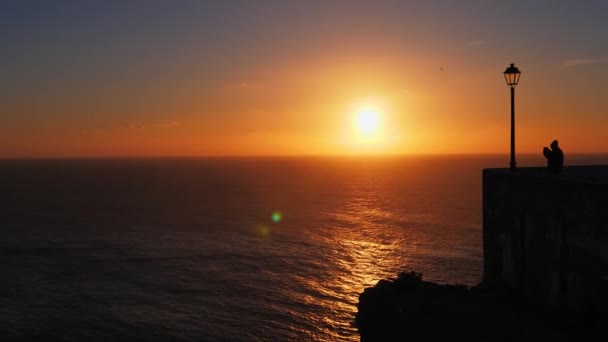 Toutist njuter av utsikten från Miradouro do Nazare vid solnedgången. Portugal — Stockvideo