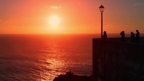 Турист наслаждается видом из отеля Miradouro do Nazare на закате — стоковое видео