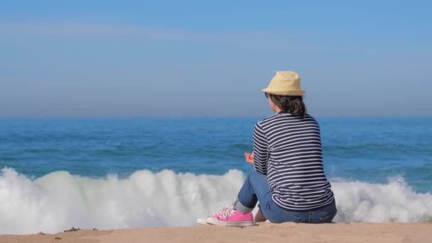 Kobieta turysta w paski koszula korzystających z widokiem na morze — Wideo stockowe