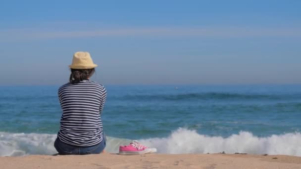 Kobieta w paski koszuli na plaży korzystających z widokiem na morze — Wideo stockowe