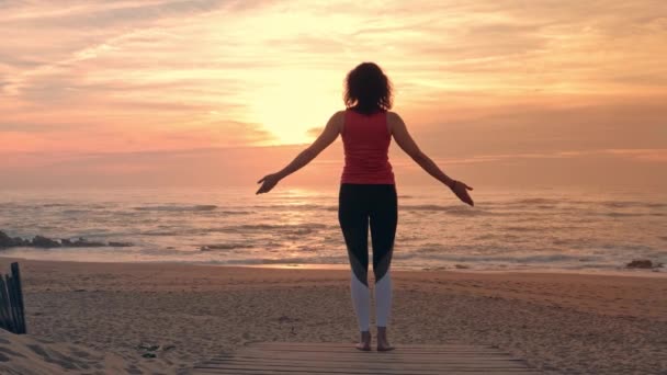 Женщина практикует йогу на пляже, спорт на открытом воздухе — стоковое видео