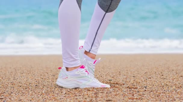 Mulher atlética na praia, aquecimento antes do exercício, preparando-se para correr — Vídeo de Stock