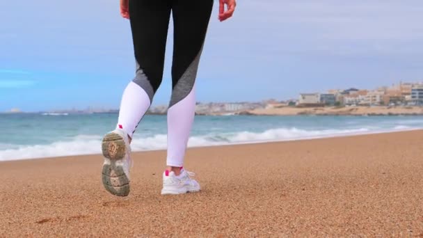 Žena kráčí po pláži oceánu, kamera se pohybuje přes nohy — Stock video