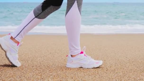 Piedi atletici che camminano sulla spiaggia, la fotocamera si muove sui piedi — Video Stock