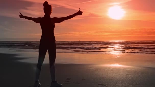 Mujer feliz en la orilla del océano, disfruta de sus éxitos deportivos — Vídeo de stock