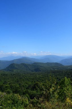 Yeşil dağlar ve mavi gökyüzü. Güzel yaz manzara çok katmanlı hills, sis ve orman. Ana Kafkas ridge, adıge.
