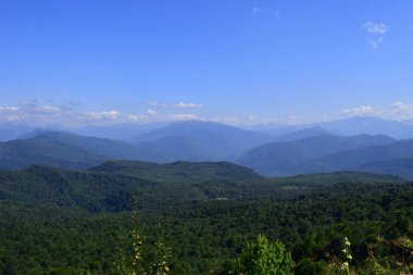 Yeşil dağlar ve mavi gökyüzü. Güzel yaz manzara çok katmanlı hills, sis ve orman. Ana Kafkas ridge, adıge.