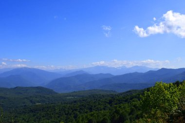 Yeşil dağlar ve mavi gökyüzü. Güzel yaz manzara çok katmanlı hills, sis ve orman. Ana Kafkas ridge, adıge.