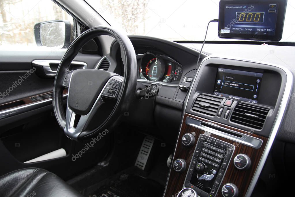 Black car interior, control panel, steering wheel and an optional navigator (location in Russian)