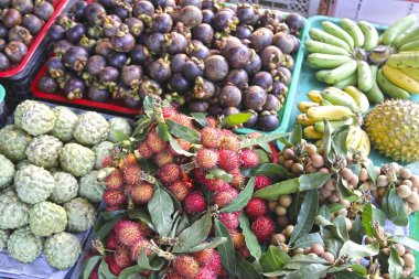 Kırmızı rambutan ve diğer tropik meyveler Pazar tezgahın üzerine.