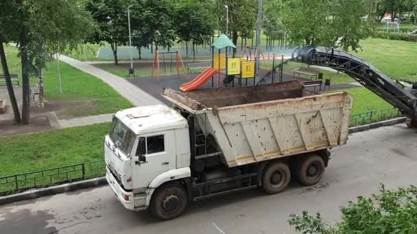 Прослеженный экскаватор на асфальтированной дороге — стоковое видео