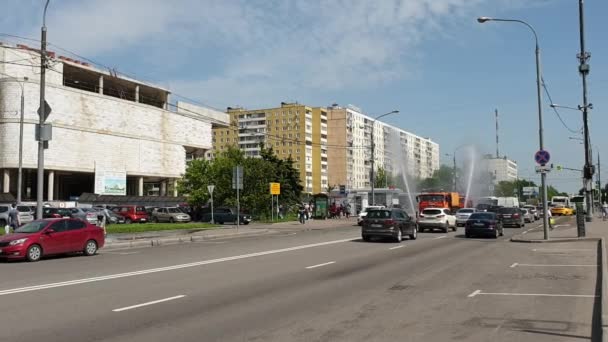 Czyszczenie zamiatarki myje miasto asfaltowej drogi z sprayem wody. — Wideo stockowe