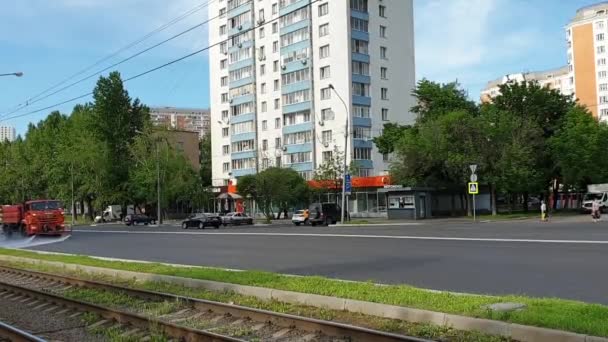 Cleaning sweeper machines washes the city asphalt road with water spray. — Stock Video