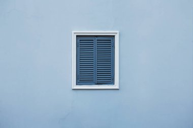 Evin kapalı bir pencere ve ayrıntıları ile mavi duvar.