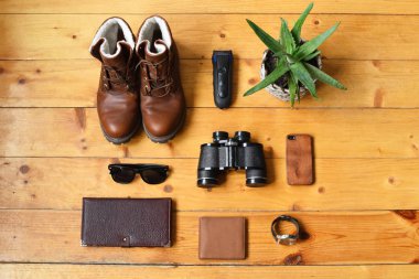Düz üst manzara, ahşap bir arka planda bir takım erkek aksesuarları..