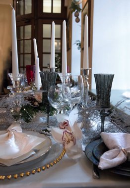 İki beyaz orkide Cymbidium Noel ayarı masa. Güzel Festival sofra, altın kenarları, Gözlük, peçete ile bir stodla beyaz masa örtüsü ile dekoratif halkaları ile plakalar. Bulanık