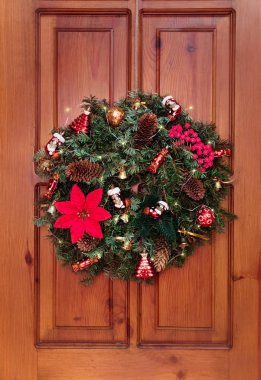 Noel ve yeni yıl için güzel dekorasyon kapı. Köknar, el yapımı çelenk Noel süslemeleri, çizmeler, şekerler, çilek, altın çan ve çelenk ile dalları. Bulanık.