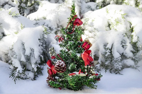Lilla julgran med leksaker i en snöig skog — Stockfoto