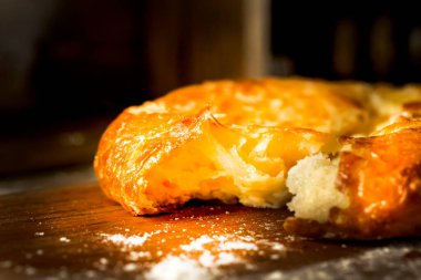 Kırık bir Türk peynirli keki ahşap bir masada yatıyor. Eski ahşap bir masada peynirli kırık pide. Gürcü Khachapuri, kubdari, peynirli lobiani. Peynirli lezzetli ekmek. Ev yapımı pişirme