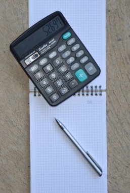 Hesap makinesi ve kalemle not defteri