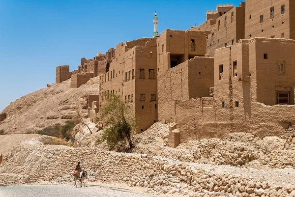2007年5月8日 在也门 Hajarayn 一名男子骑着驴子在泥土和石头的建筑物前骑马 在其他阿拉伯国家中 也门于2012年成为内战的场所 但仍在继续 — 图库照片