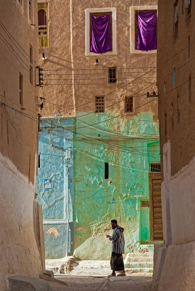 Geleneksel giysiler içinde genç bir adam üzerinde 8 Mayıs 2007 Şibam, Yemen dar sokaklarda yürüyor. Şibam eski şehir Unesco Dünya Miras kenti olduğunu.