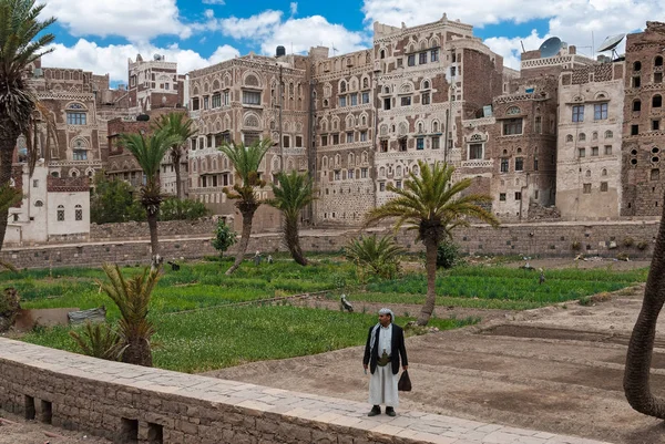 2007年5月4日 也门萨那 一位穿着传统服装的男子站在多层建筑的前面 萨那老城是联合国教科文组织的世界遗产城市 — 图库照片