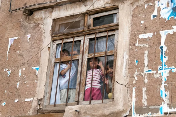 三快乐的男孩笑和挥动他们的手在窗口酒吧在2007年5月4日在也门的萨那 虽然婴儿死亡率很高 但也门的儿童在文化和社会价值上 — 图库照片