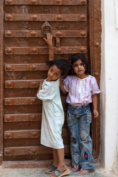 2007年5月8日 在也门 Shibam 两名女孩敲了家的旧木门 对着镜头摆姿势 — 图库照片