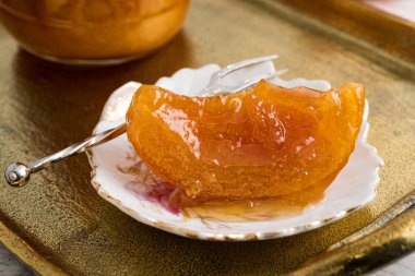 Ev yapımı turuncu bir tatlı kaşık ve kavanoz vintage bronz tepsi tam.