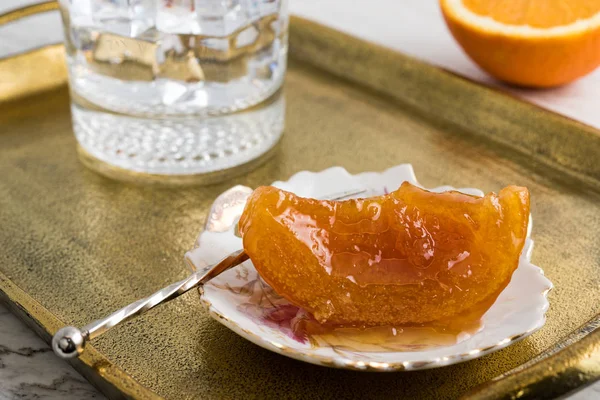 自家製オレンジ色スプーン甘くてビンテージ ブロンズ トレイに冷たい水のグラス — ストック写真