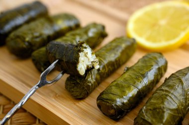 Lezzetli dolma yaprak (Akdeniz mutfağının geleneksel dolma) limon dilimi ile ahşap tepsi