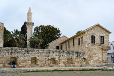 Larnaka, Kıbrıs 24 Mart 2019: Larnaka kalesinin duvarlarının dışında bir erkek ve bir kadın oturun