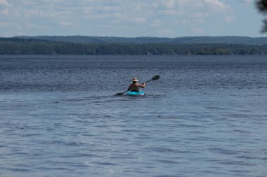 Sıcak bir yaz gününde büyük gölde kayak yapan bir adam. 
